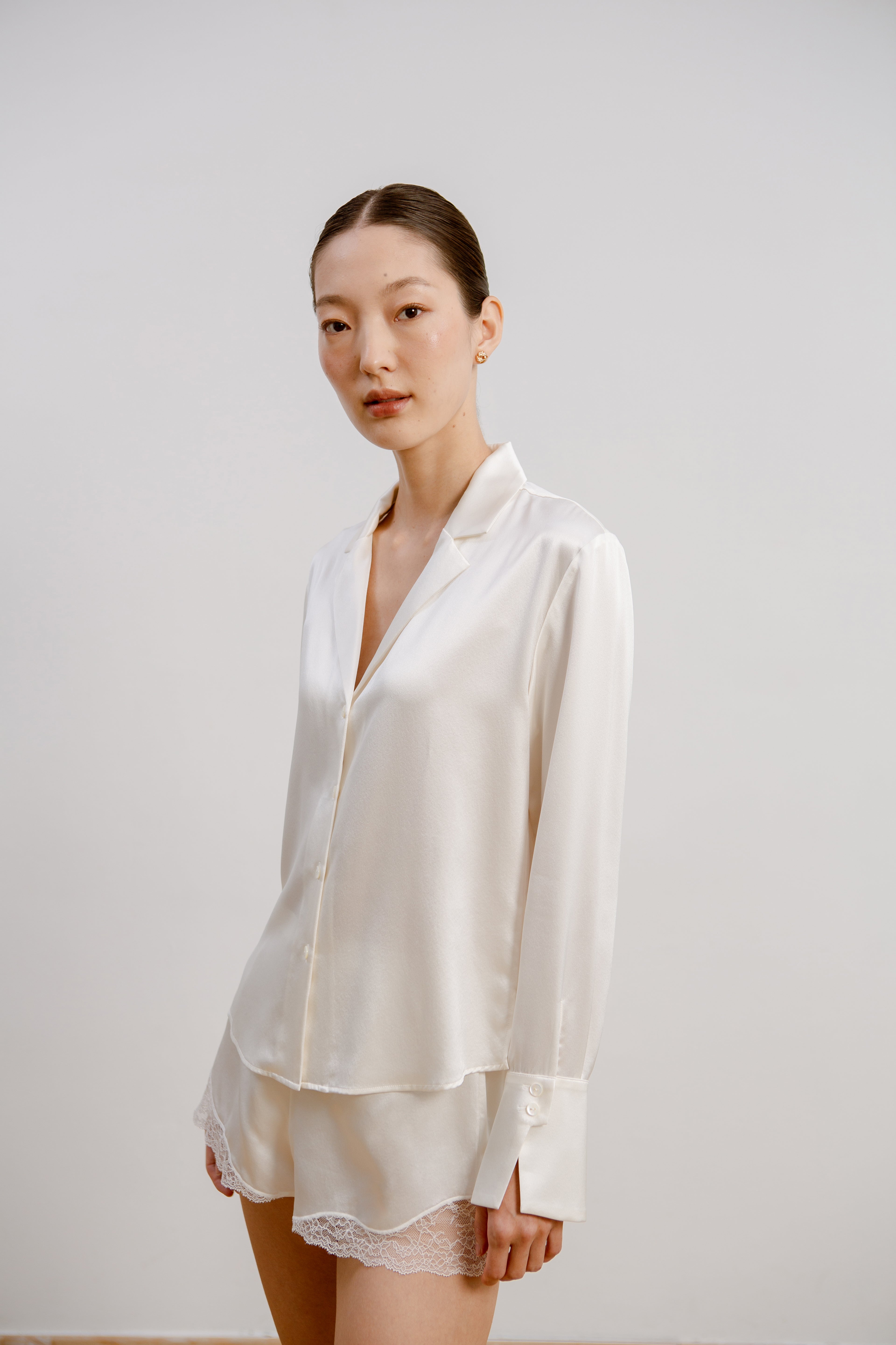 Model wearing the silk ivory shirt and lace shorts